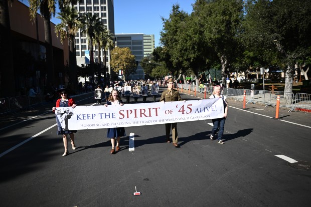 Members of Keep the Spirit of ’45 Alive march in...