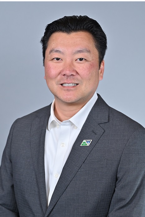 man facing camera dressed in white shirt and grey blazer