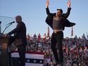 Elon Musk jumps on the stage as Donald Trump speaks at a campaign rally at the Butler Farm Show, Saturday, Oct. 5, 2024, in Butler, Pa.