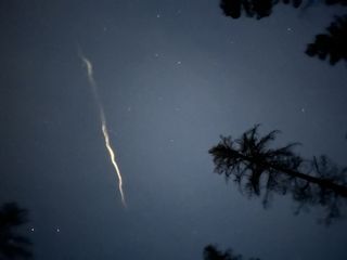 a bright green streak of light in the sky