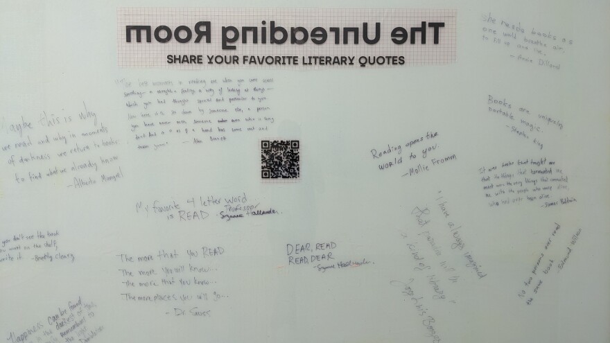 A whiteboard is shown covered in quotes about literature and reading. A QR is in the center. 