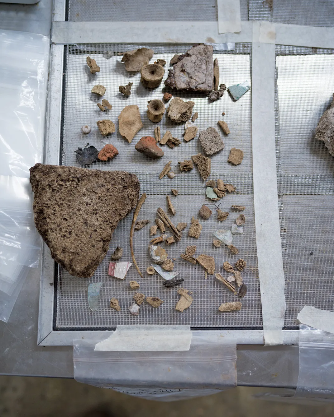 Assorted fragments of bone, pottery, metal and glass from the Smith’s Island site are categorized by material, cataloged and dated.