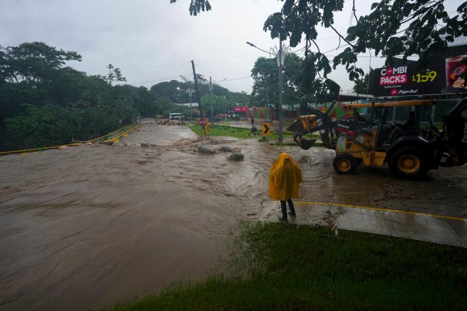 A worker stands alongside an overflowing river flooded by rains brought on by Tropical Storm Sara in San Pedro Sula, Honduras, last weekend. Honduras could see even more flooding on Monday. The Gulf Coast of the US could also feel the storm later in the week ((AP Photo/Moises Castillo))