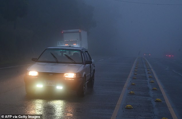 A car drives through heavy fog ahead of the arrival of tropical storm Sara in Siguatepeque, Honduras on November 14, 2024