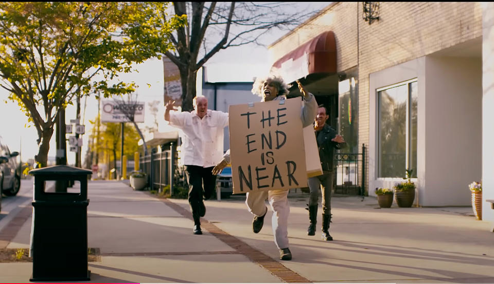 Person running on a sidewalk holding a sign that says 