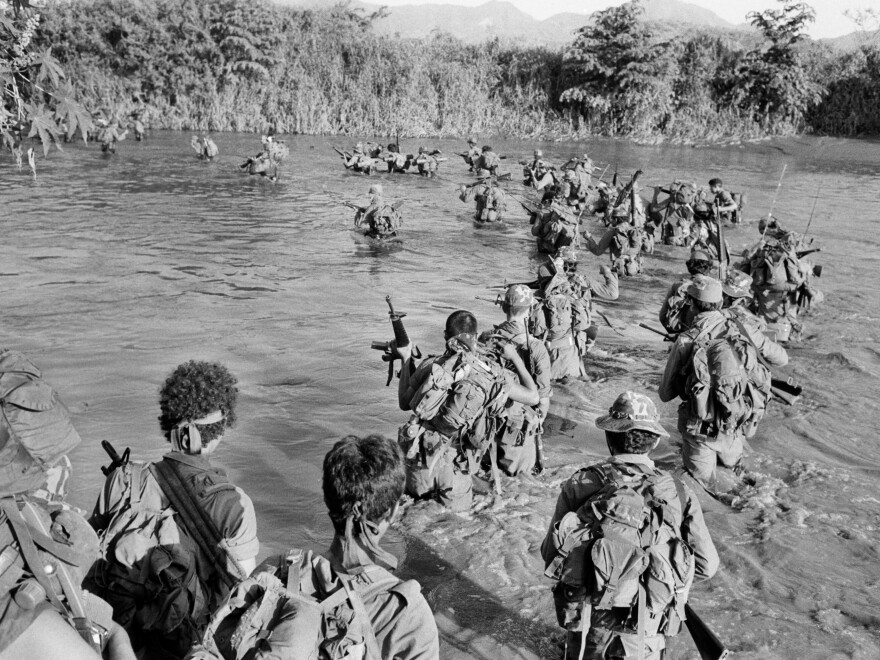 Salvadoran members of the Atlacatl battalion cross a river during a military operation in San Miguel department, El Salvador, sometime in late August or early September 1983.