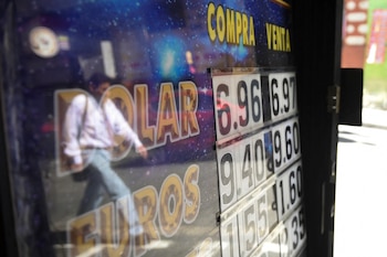 Una persona se refleja en el letrero de una casa de cambio en La Paz (REUTERS/Claudia Morales)