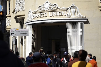 Personas caminan frente al Banco Unión mientras el país enfrenta una grave escasez de dólares estadounidenses, en La Paz (REUTERS/Claudia Morales)