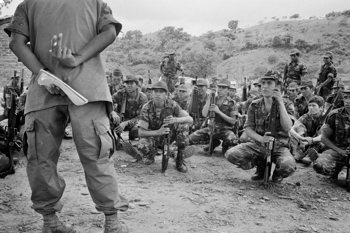 A U.S. Army advisor (left) leads Salvadoran army soldiers during an open air class in San Juan Opico, El Salvador, on June 20, 1983.