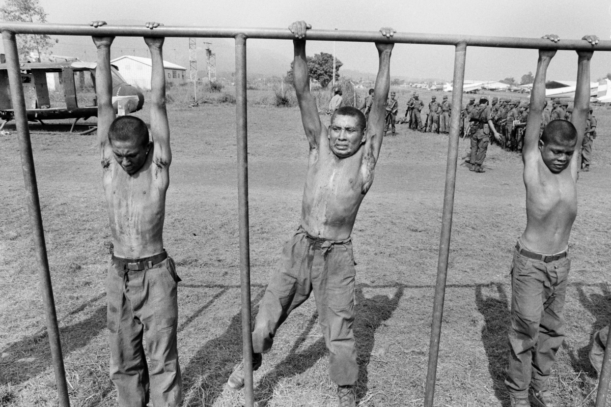 Salvadoran army recruits hang from a crossbar during a training exercise overseen by U.S. Army Rangers and Special Forces at the Ilopango air base in San Salvador, El Salvador, in March 1983.