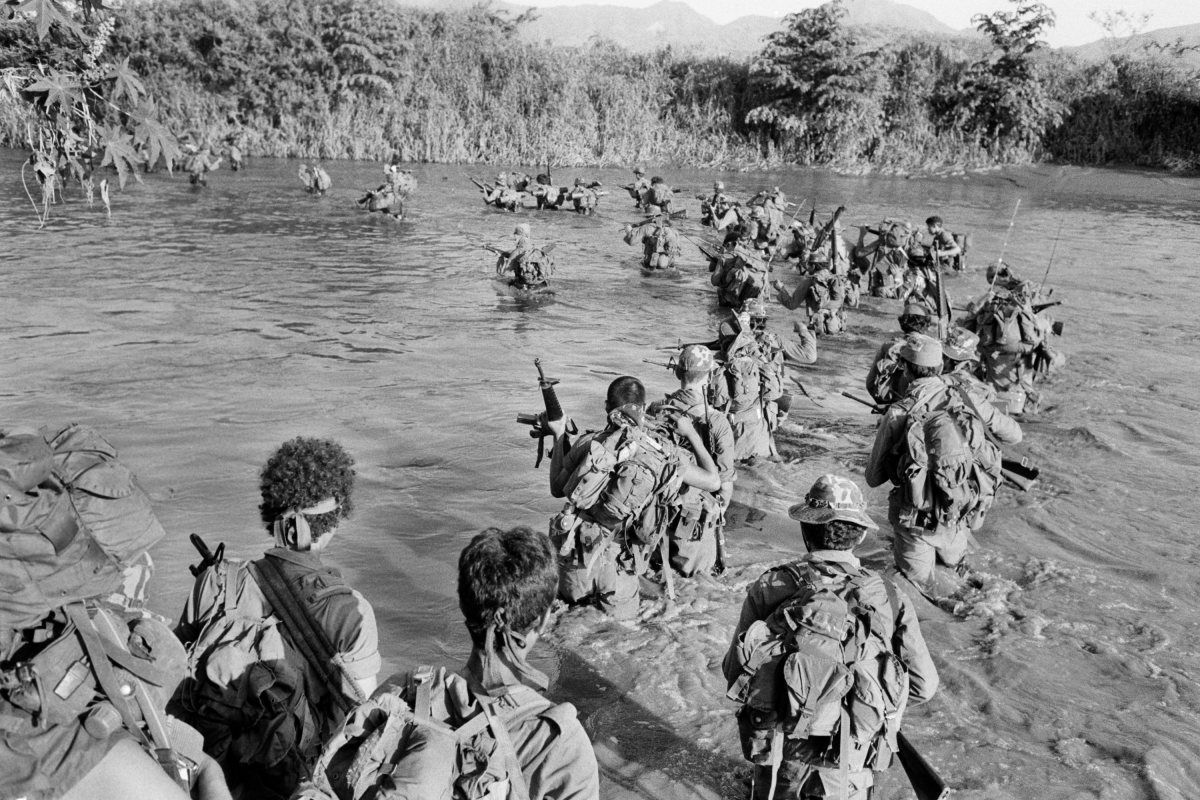 Salvadoran members of the Atlacatl battalion cross a river during a military operation in San Miguel department, El Salvador, sometime in late August or early September 1983.