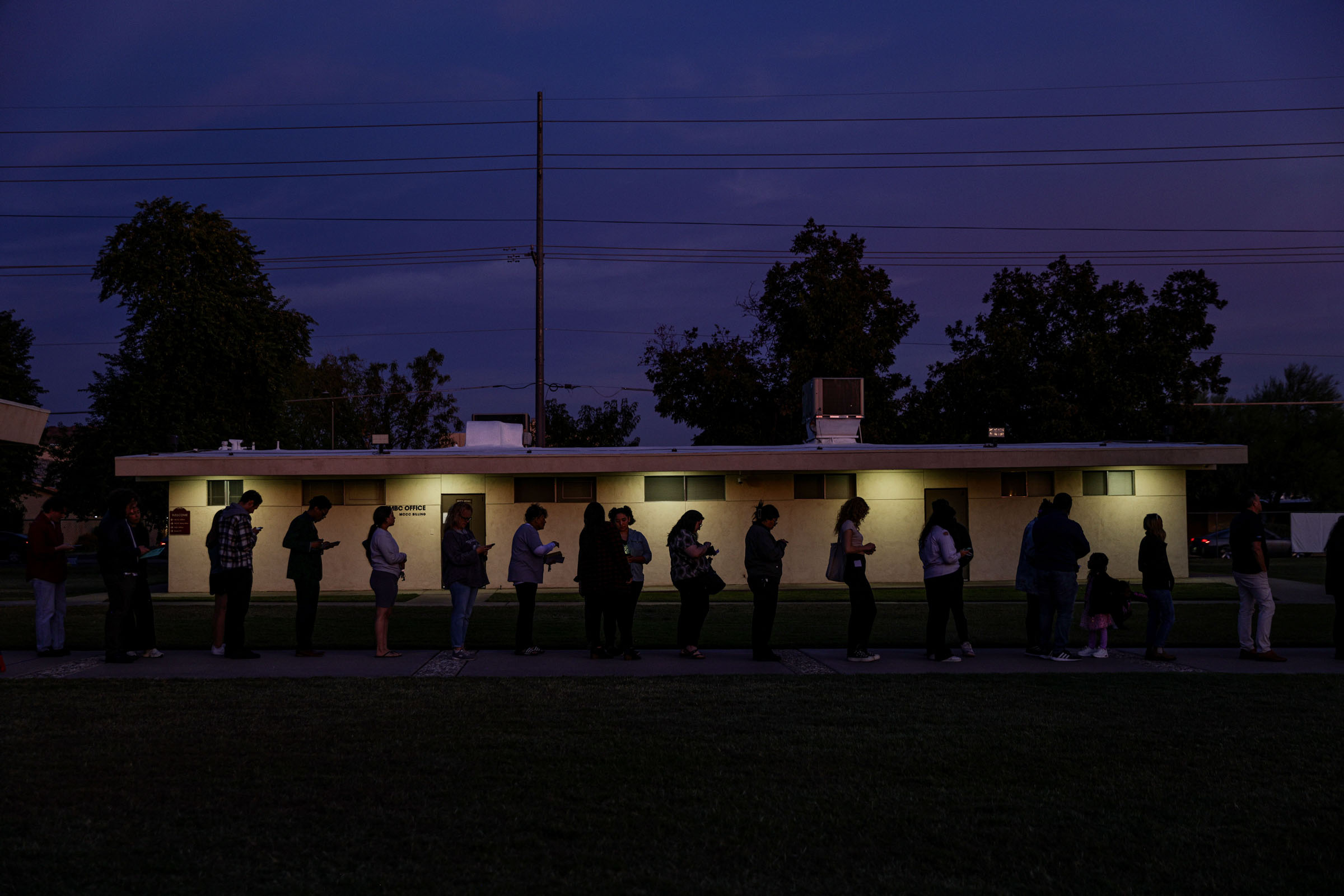 Voters wait in line at sunset to cast their ballots at a polling location inside a church in Phoenix, Ariz., on Election Day, Tuesday, Nov. 5, 2024. (Adriana Zehbrauskas/The New York Times)