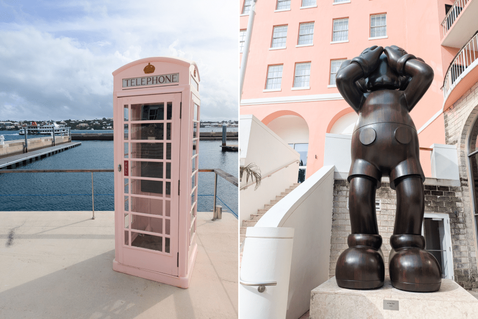 A photo featuring a pastel pink British-style telephone booth overlooking calm blue waters on a dock, paired with a large bronze KAWS sculpture titled At This Time in front of the pink facade of the Hamilton Princess hotel, blending playful art with Bermuda’s picturesque surroundings.