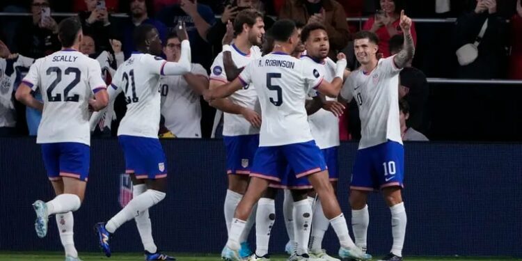 Christian Pulisic (right) is congratulated by teammates after scoring one of his goals in Monday's game.