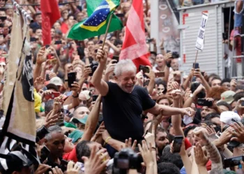 Sao Bernardo do Campo, SP, Brazil - November 9, 2019: Brazil's former President Luiz Inacio Lula da Silva waves a Brazilian flag as he is carried by supporters during a political rally.