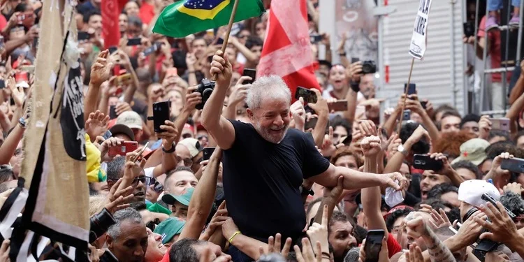 Sao Bernardo do Campo, SP, Brazil - November 9, 2019: Brazil's former President Luiz Inacio Lula da Silva waves a Brazilian flag as he is carried by supporters during a political rally.