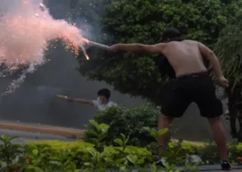 Reuters Supporters of Luis Fernando Camacho, the governor of Santa Cruz and a prominent opposition leader, fire firecrackers towards police officers during a protest following Camacho's detention by the Bolivian police, in Santa Cruz de la Sierra, Bolivia December 28, 2022.