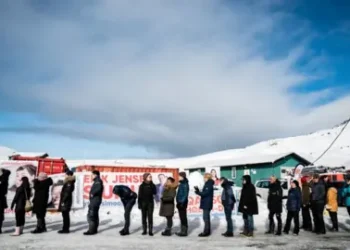 Reuters Voters stand in line waiting to cast their votes during the parliamentary election, outside the Inussivik arena, in Nuuk, Greenland