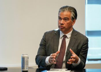 A photo of Rob Bonta gesturing with his hands during an interview.