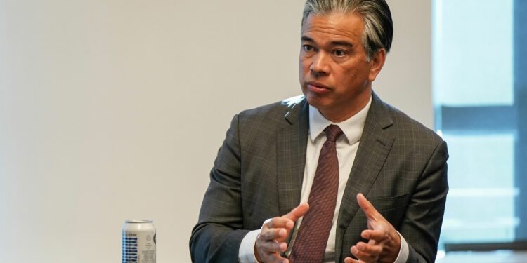 A photo of Rob Bonta gesturing with his hands during an interview.