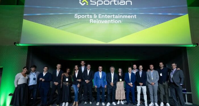 A group of people stands on stage under a large presentation screen displaying the ‘Sportian’ logo and the phrase ‘Sports & Entertainment Reinvention’