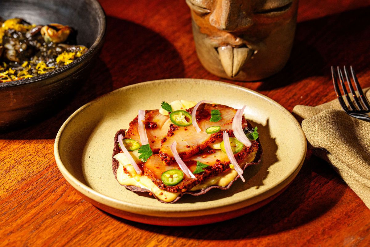 A hamachi al pastor tostada on a plate.