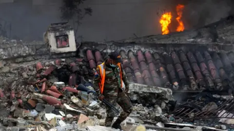 EPA A member of Dominican Army walks at the site of the explosion in San Cristabal, some 30km from Santo Domingo, Dominican Republic - 14 August 2023.