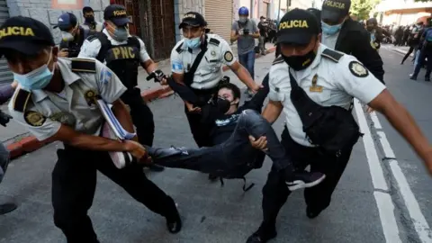 Reuters Police officers carry a demonstrator in Guatemala City. Photo: 21 November 2020