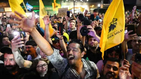 Getty Images Supporters of Argentine presidential candidate for the La Libertad Avanza alliance Javier Milei celebrate after polls closed during the presidential election runoff outside the party headquarters in Buenos Aires on November 19, 2023.