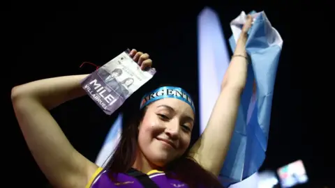 Getty Images A supporter of newly elected President of Argentina Javier Milei of La Libertad Avanza celebrates after the polls closed in the presidential runoff on November 19, 2023 in Buenos Aires, Argentina.