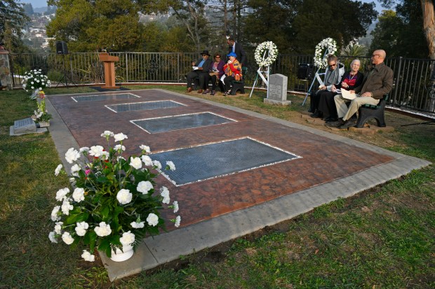 Jonestown survivors gather near large plaques remembering the people that...