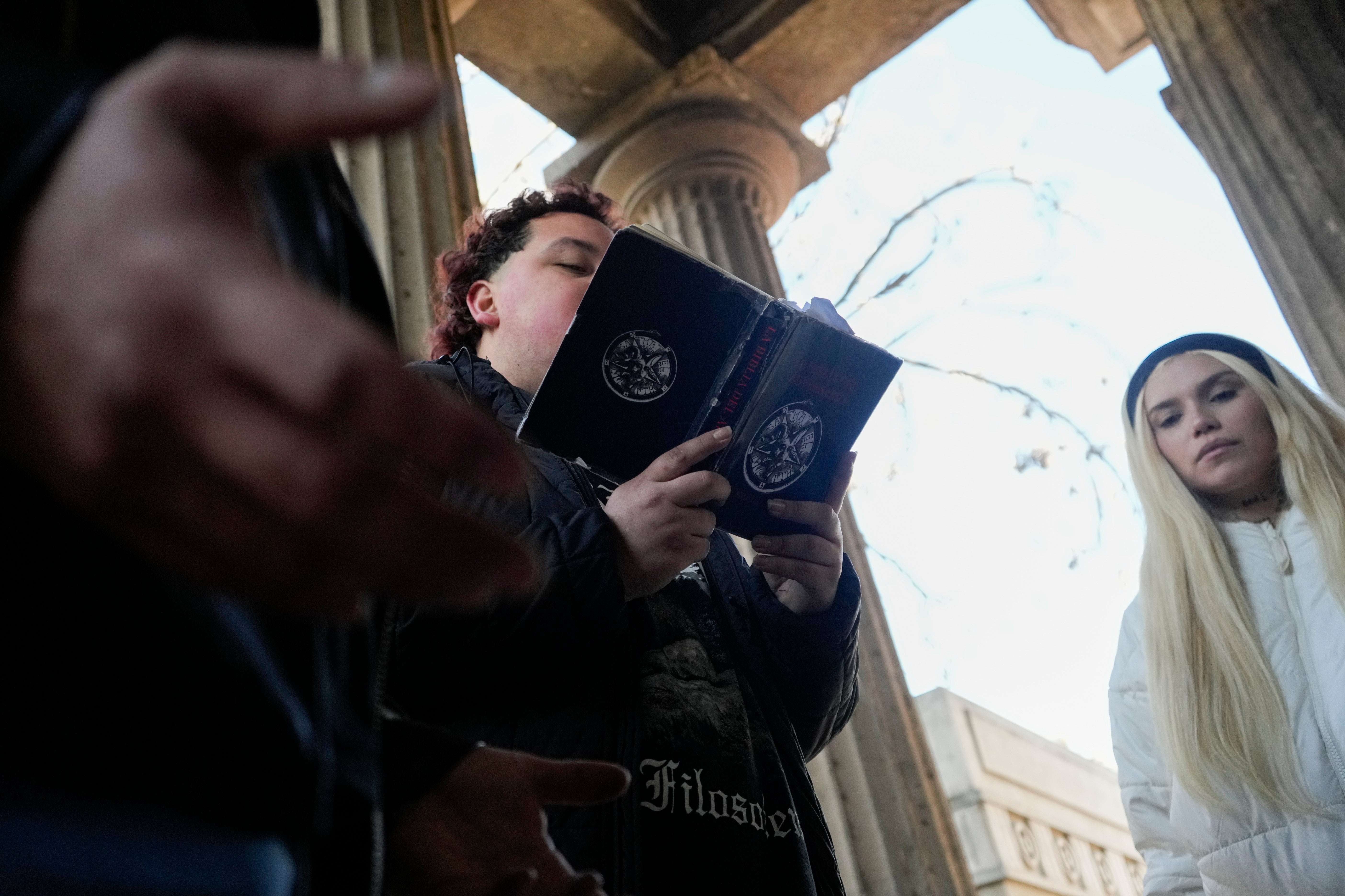 A member of The Temple of Satan: Satanists and Luciferians of Chile reads from The Bible of the Adversary by Michael Ford, during a ceremony at the General Cemetery in Santiago