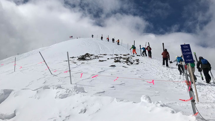 skiers hike Peak 8 off the Imperial SuperChair, accessing Lake Chutes and Snow White terrain