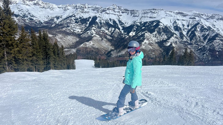 snowboarder taking in endless views of the San Juans from Telluride Mountain