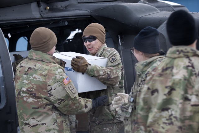 Alaska Army National Guardsmen from the 207th Aviation Troop Command and Bison Company, 1st Battalion, 297th Infantry Regiment, offload boxes of frozen meat from a UH-60L Black Hawk helicopter during an Innovative Readiness Training mission at...