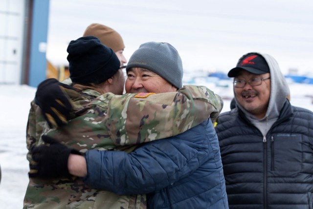 Alaska Army National Guard Chief Warrant Officer 2 Morgan Osborn, left, a UH-60L Black Hawk pilot with the 207th Aviation Troop Command greets local resident, Nick Therchik, after delivering thousands of pounds of frozen meat during an Innovative...