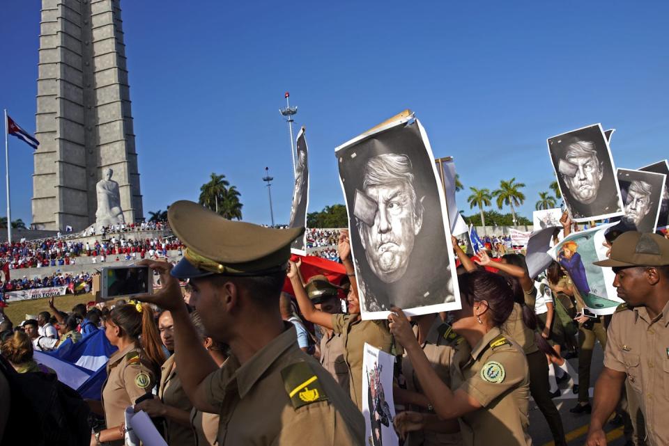 Protestors hold aloft caricatures of a man.