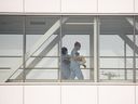 Health-care workers walk across a sky bridge at a hospital in Montreal, Que.