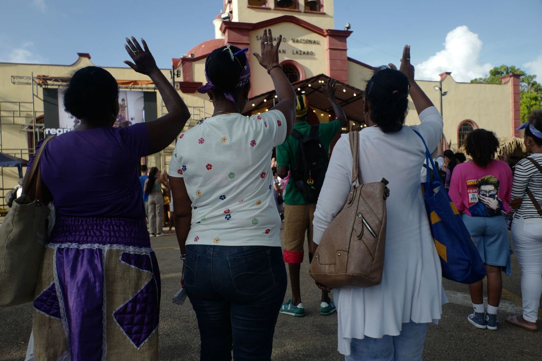 Women take part in an outdoor mass at El Rincón church. Both Cuba’s Catholics and practitioners of the Santería religion participate in the pilgrimage, one of the most significant public expressions of faith to occur in Cuba,