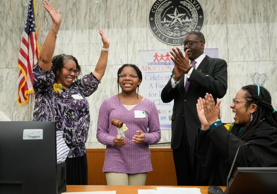 Eshana Horton, 12, strikes the gavel with Judge Aurora Martinez Jones, right, to finalize her adoption by her parents, Shalonda and Daryl Horton, during Austin Adoption Day at the Travis County Civil and Family Courts Facility in Austin, Texas.