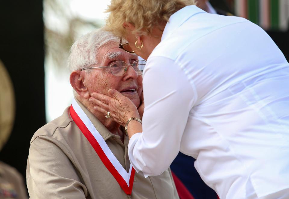 Gold Star Mother Michelle Dale embraces World War II Veteran Bill Keegan on the stage of the new World War II tribute on Veterans Day at Veterans Memorial Island Sanctuary in Vero Beach., Fla.