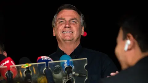 Getty Images Incumbent and candidate Jair Bolsonaro of Liberal Party (PL) talks during a press conference at the end of the general elections day at the main entrance of Alvorada Palace on October 02, 2022