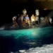 Royal Bahamas Defence Force via Reuters Survivors of a migrant boat that capsized perch on the overturned vessel off the coast of New Providence