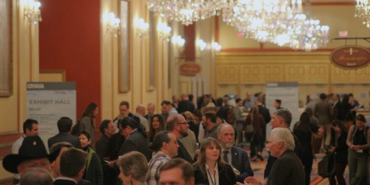 People mingle in the hallway of the Colorado River Water Users Association conference at the Paris Hotel in Las Vegas on December 5, 2024. The event brought together more than 1,500 water experts from across the Southwest.