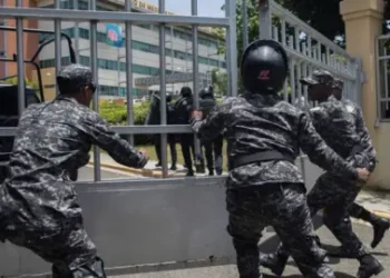 Getty Images Police scramble to enter the ministerial premises after a friend of Orlando Jorge Mera shot and killed him in his office