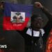 A man drives past a burning barricade during a protest against Prime Minister Ariel Henry's government and insecurity, in Port-au-Prince, Haiti March 1, 2024