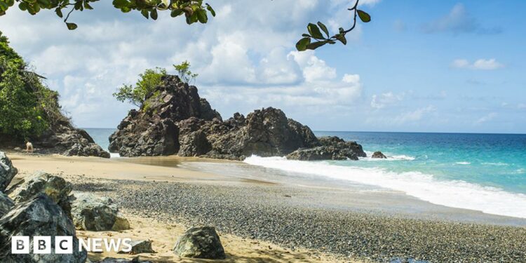 A general view of Turtle Beach, Tobago (also known as Courland Bay) showing sand, rocks, blue sea and sky