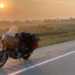 Sean Drysdale A motorbike is parked by the side of a country road in America with sun beginning to set in the distance amid rolling farmland