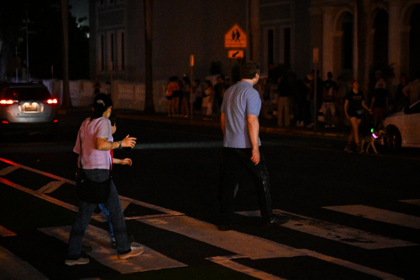 SAN JUAN, PUERTO RICO - DECEMBER 31: People walk on a dark street on December 31, 2024 in San Juan, Puerto Rico. The majority of the population on the island is without electricity due to a major power outage. (Photo by Miguel J. Rodriguez Carrillo/Getty Images)