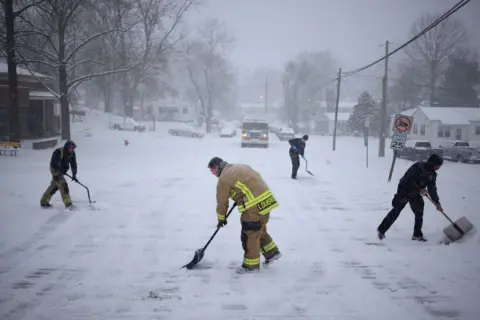 Getty Images Firefighters shovel snow in Louisville, Kentucky, on 5 January 2025 